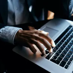 Dłoń na klawiaturze laptopa, szukamy informacji, jak sprawdzić ile ma się lat pracy.