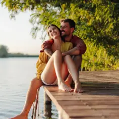 Szczęśliwa para na pomoście nad jeziorem. Czas na relaks i zastanowienie się, jak sprawdzić ile przysługuje mi urlopu.