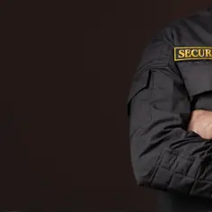 Pracownik ochrony w czarnej kurtce z naszywką "SECURITY". Zastanawiasz się, ile zarabia pracownik ochrony z bronią?