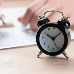 Budzik obok dokumentów. Czas na egzaminy zawodowe.