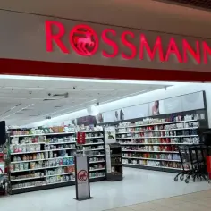 Wejście do drogerii Rossmann. Zastanawiasz się, ile zarabia pracownik Rossmanna? W środku półki pełne kosmetyków i artykułów higienicznych.