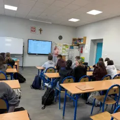 Nauczycielka omawia z uczniami ofertę edukacyjną, pokazując ile jest lekcji doradztwa zawodowego.