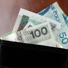 Portfel z polskimi banknotami 100 zł i 50 zł. Zastanawiasz się, ile wynosi najniższa krajowa na godzinę?
