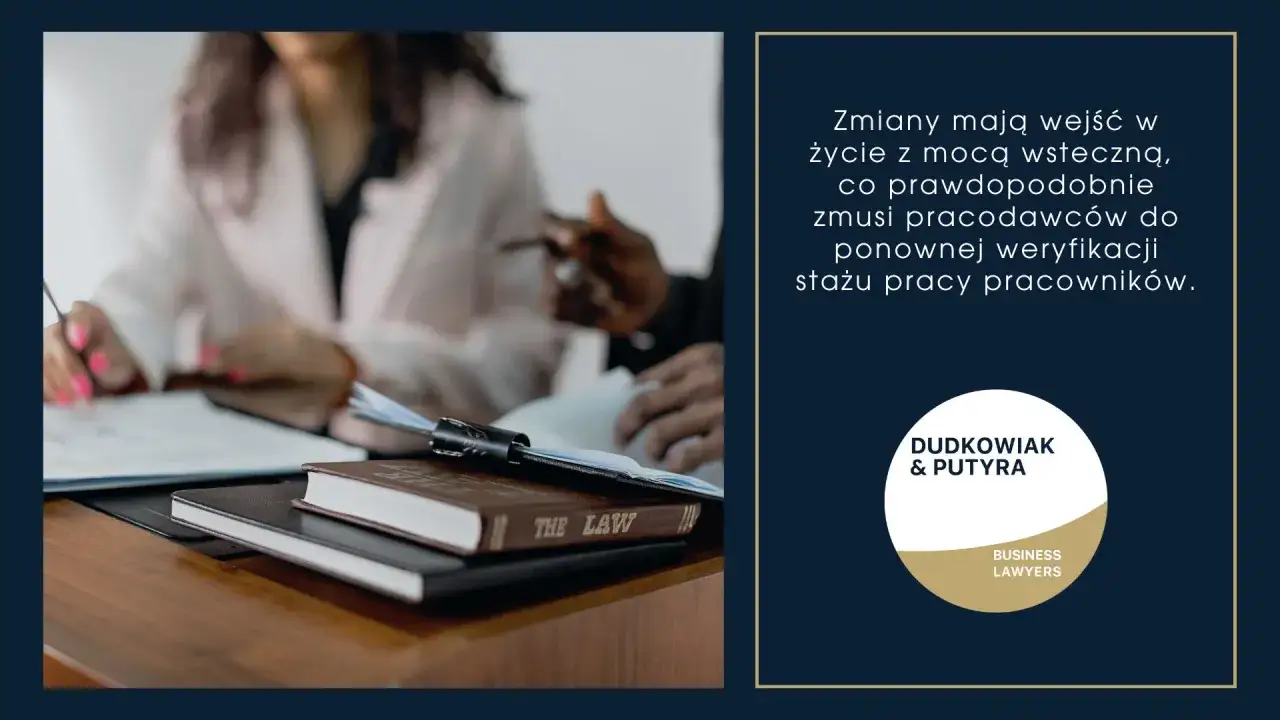 Dwie osoby analizują dokumenty przy biurku z książką 