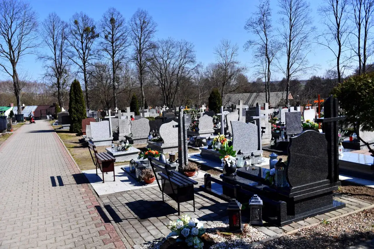 Cmentarz z nagrobkami i alejkami. Zastanawiasz się, ile zarabia grabarz?