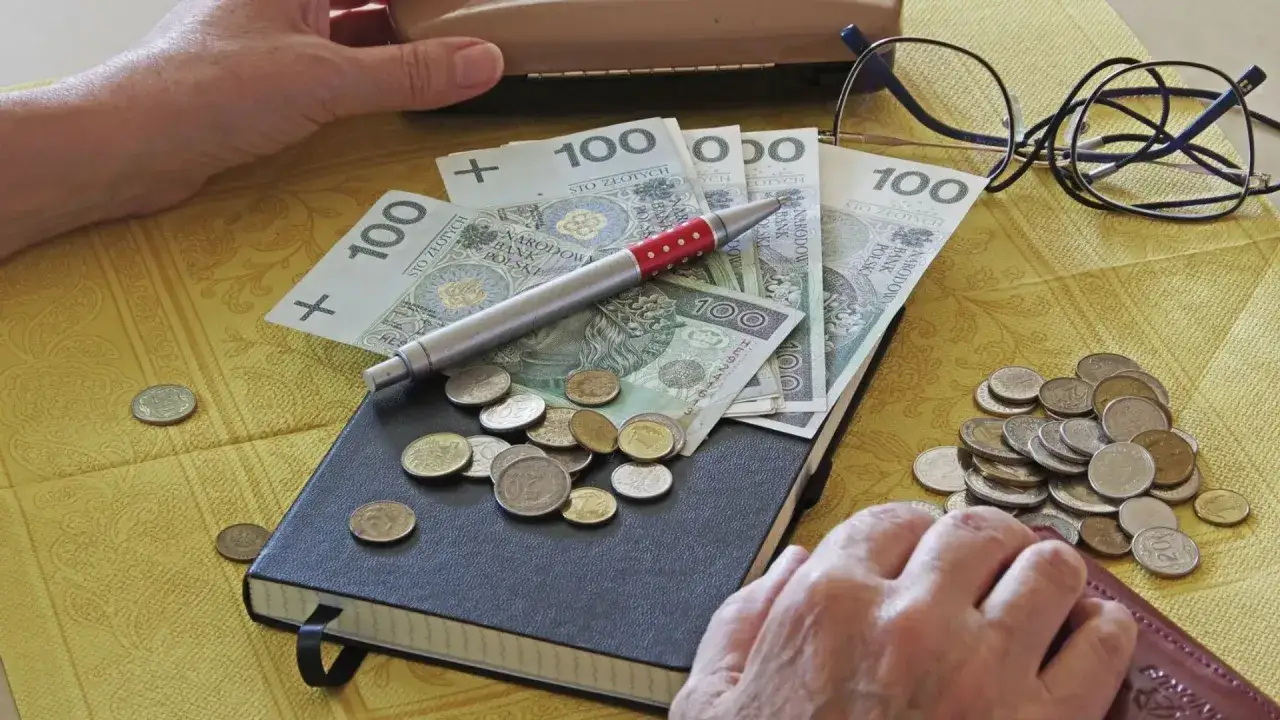 Kiedy kierowca zawodowy może przejść na emeryturę? Na stole leżą pieniądze, notatnik i okulary, symbolizując planowanie finansowe.
