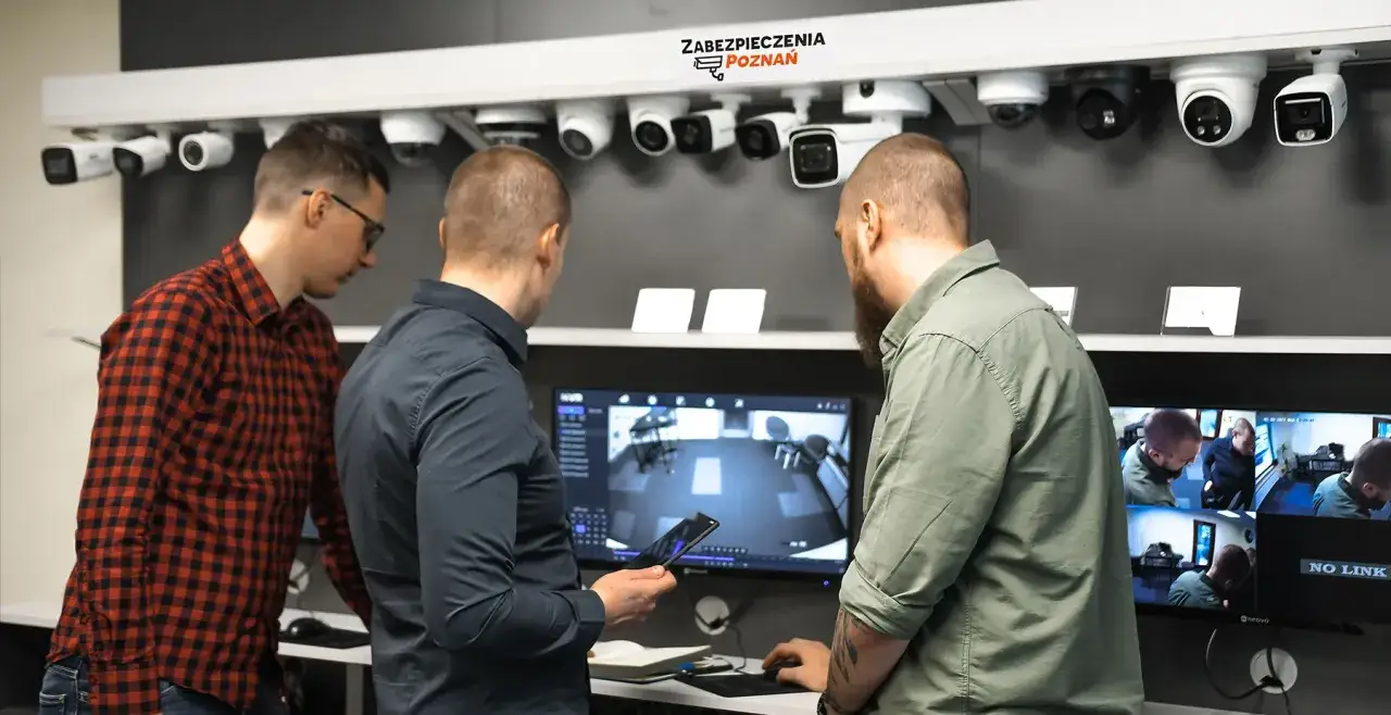 Trzech mężczyzn ogląda monitoring. Czy pracodawca może nagrywać pracownika bez jego zgody? Systemy monitoringu wizyjnego.