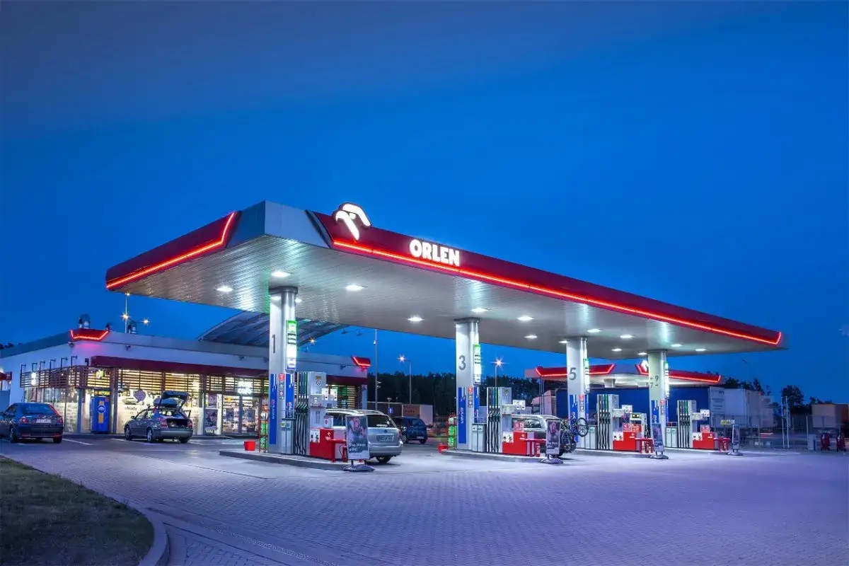 Nocna stacja Orlen z dystrybutorami i samochodami. Ciekawe, ile zarabia kierownik stacji Orlen?