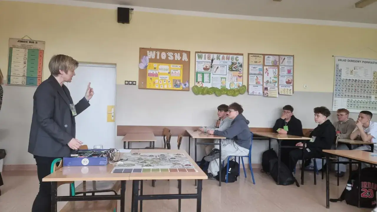 Nauczycielka wyjaśnia uczniom, co to jest wykształcenie zasadnicze zawodowe, podczas lekcji w sali lekcyjnej.