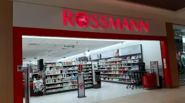 Wejście do drogerii Rossmann. Zastanawiasz się, ile zarabia pracownik Rossmanna? W środku półki pełne kosmetyków i artykułów higienicznych.