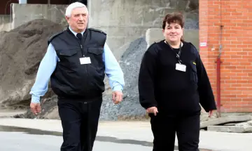 Dwóch ochroniarzy w kamizelkach i czarnych swetrach idzie obok siebie. Zastanawiasz się, ile zarabia ochroniarz w banku?
